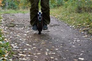 vue de face des jambes masculines sur un monocycle dans la forêt photo
