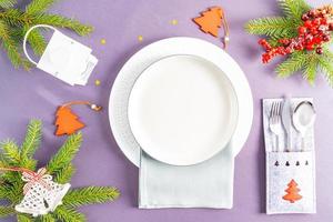 servir la table du nouvel an. assiettes vides et couverts en or avec décorations. image conceptuelle pour le menu et l'affiche. une assiette vide festive. photo