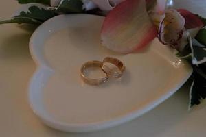 anneaux de mariage sur une soucoupe blanche photo