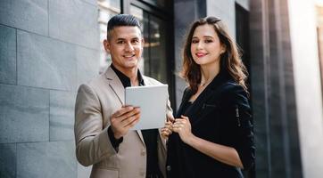 concept de travail d'équipe ou de travail ensemble. portrait d'un homme d'affaires et d'une femme d'affaires travaillant sur une tablette à l'extérieur du bureau photo