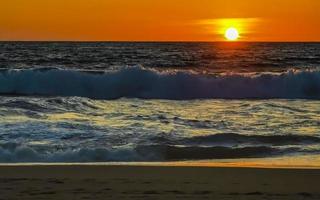 coucher de soleil doré coloré grande vague et plage puerto escondido mexique. photo