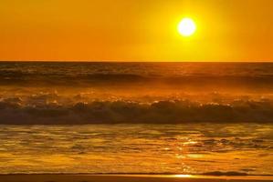 coucher de soleil doré coloré grande vague et plage puerto escondido mexique. photo