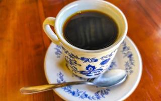 pot de tasse blanc bleu avec table basse en bois noir mexique. photo