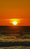 coucher de soleil doré coloré grande vague et plage puerto escondido mexique. photo