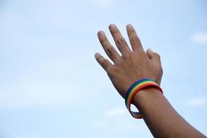 bracelet arc-en-ciel portant à la main de jeunes homosexuels asiatiques pour montrer et représenter la diversité des sexes, respecter les droits de l'homme dans le sexe alternatif, arrêter de punir les homosexuels dans certaines religions photo