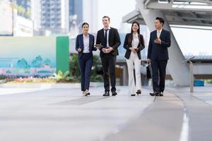 les gens d'affaires marchent et se parlent devant un bureau moderne photo