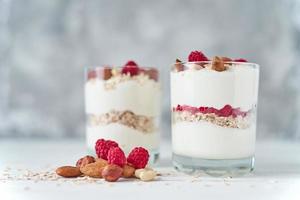 deux verres de granola de yaourt grec aux framboises, flocons d'avoine et noix photo