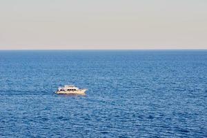 bateau de pêche à la traîne dans une eau bleue de l'océan photo