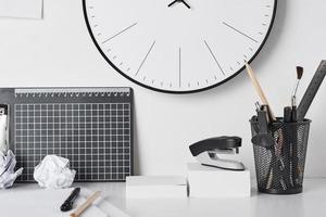 fournitures de bureau et horloge murale sur blanc photo