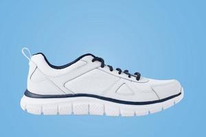 une baskets blanches masculines sur fond bleu. chaussure de sport gros plan photo