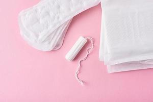 serviette hygiénique et tampon menstruel sur fond rose photo