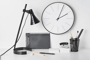 fournitures de bureau, lampe et horloge murale sur blanc photo