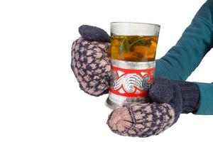 mains féminines en mitaines, tenant un vieux verre avec du thé. photo