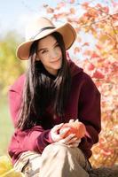 heureuse jeune fille avec citrouille dans le jardin d'automne photo