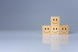 sourit sur le cube. il représente les évaluations positives, les commentaires et les avis des clients. concept de satisfaction, enquête de satisfaction, évaluation de la santé mentale, concept de pensée positive. photo