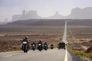 Les touristes à moto sur l'autoroute à Monument Valley Park en été photo