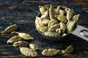 gousses de cardamome verte renversées d'une cuillère à café photo