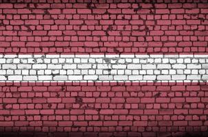 le drapeau de la lettonie est peint sur un vieux mur de briques photo