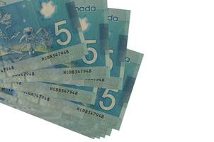 5 billets de dollars canadiens se trouvent dans un petit groupe ou un paquet isolé sur blanc. maquette avec espace de copie. commerce et change photo