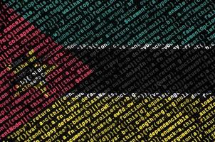 Le drapeau mozambicain est représenté à l'écran avec le code du programme. le concept de technologie moderne et de développement de site photo