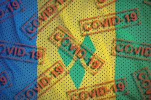 drapeau de saint vincent et les grenadines et de nombreux timbres rouges covid-19. coronavirus ou concept de virus 2019-ncov photo