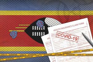 drapeau du swaziland et formulaire de demande d'assurance maladie avec cachet covid-19. coronavirus ou concept de virus 2019-ncov