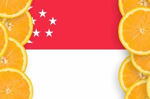 drapeau de singapour dans le cadre vertical de tranches d'agrumes photo