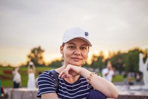 portrait d'une jeune fille coiffée d'une casquette sur fond de paysage urbain en plein air. voyager. mode de vie dans la ville. centre, rues photo