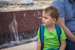 portrait d'un enfant, d'un garçon sur fond de paysages urbains de gratte-ciel et d'immeubles de grande hauteur en plein air. enfants, voyages. mode de vie dans la ville. centre, rues. photo