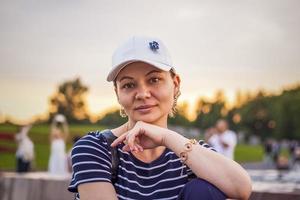 portrait d'une jeune fille coiffée d'une casquette sur fond de paysage urbain en plein air. voyager. mode de vie dans la ville. centre, rues photo