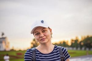 portrait d'une jeune fille coiffée d'une casquette sur fond de paysage urbain en plein air. voyager. mode de vie dans la ville. centre, rues photo