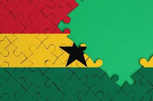 le drapeau du ghana est représenté sur un puzzle terminé avec un espace de copie vert gratuit sur le côté droit photo