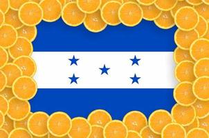 drapeau du honduras dans un cadre de tranches d'agrumes frais photo