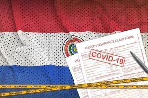 drapeau du paraguay et formulaire de demande d'assurance maladie avec cachet covid-19. coronavirus ou concept de virus 2019-ncov photo