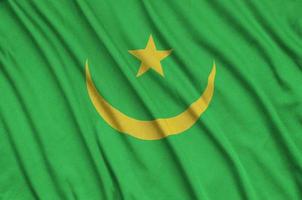 le drapeau de la mauritanie est représenté sur un tissu de sport avec de nombreux plis. bannière de l'équipe sportive photo