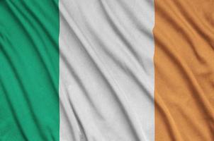 Le drapeau irlandais est représenté sur un tissu de sport avec de nombreux plis. bannière de l'équipe sportive photo