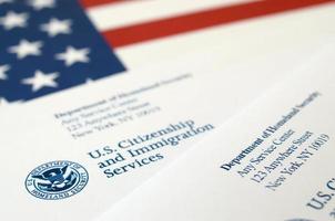 enveloppes avec lettre de l'uscis sur le drapeau des états-unis du département de la sécurité intérieure photo
