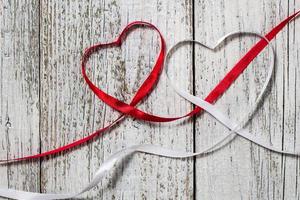 coeurs de ruban rouge et blanc pour la saint valentin sur fond de bois photo