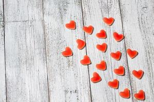 forme de coeur de bonbons rouges marmelade sucrée sur une table en bois blanc, composition de la saint-valentin avec espace pour copie photo