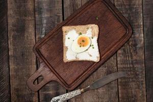 le pain a du fromage à la crème et de la grenade sur fond de bois. photo