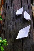 origami, bateau en papier blanc isolé sur un plancher en bois. les bateaux en papier signifient marcher. sentiment de liberté leadership photo