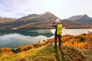 l'homme observe le paysage d'automne à un lac de montagne photo