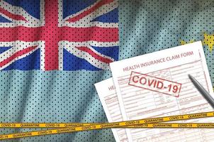drapeau tuvalu et formulaire de demande d'assurance maladie avec cachet covid-19. coronavirus ou concept de virus 2019-ncov photo