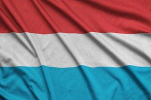 le drapeau luxembourgeois est représenté sur un tissu de sport avec de nombreux plis. bannière de l'équipe sportive photo