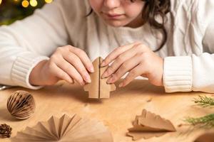 fille fait des décorations d'arbre de noël en papier avec ses propres mains. instruction étape par étape photo