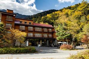 kamikochi, nagano, japon - octobre 2022 hôtel non identifié pour les touristes dans le parc national de kamikochi avec un beau fond de saison de feuillage d'automne dans les alpes japonaises. photo