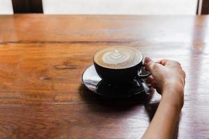 main de femme tenant une tasse de café au café. photo