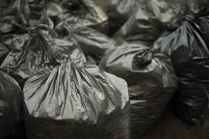 sacs poubelles noirs. nettoyage dans la rue. sacs à déchets. plastique noir. photo