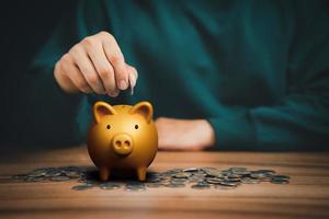 homme mettant une pièce dans une tirelire pour économiser de l'argent, le financement des entreprises et l'investissement. photo