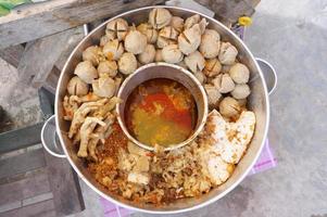 bakso setan d'indonésie. soupe de boulettes de viande super épicée avec nouilles, pattes de poulet, tofu et graisse de boeuf. mise au point sélective. photo